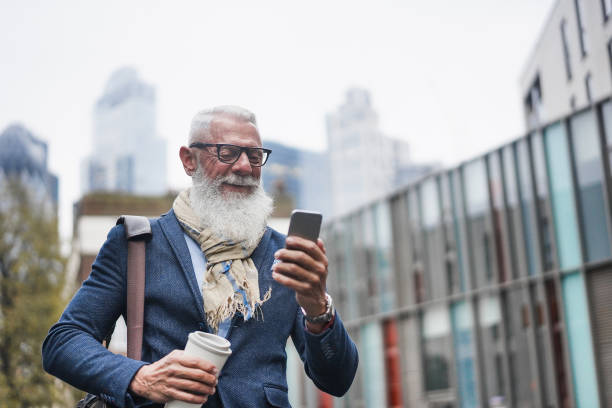 istock Senior businessman using mobile phone while going to work - Hipster entrepreneur outdoor during fall time - Job, business, elegant, fashion and confident concept - Focus on face 1270034374