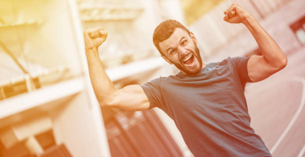 istock Excited handsome bearded man is shouting with hands raised up due to winning on game 1270038549