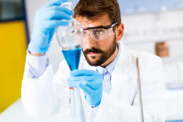 Photo of Researcher working with blue liquid at separatory funnel