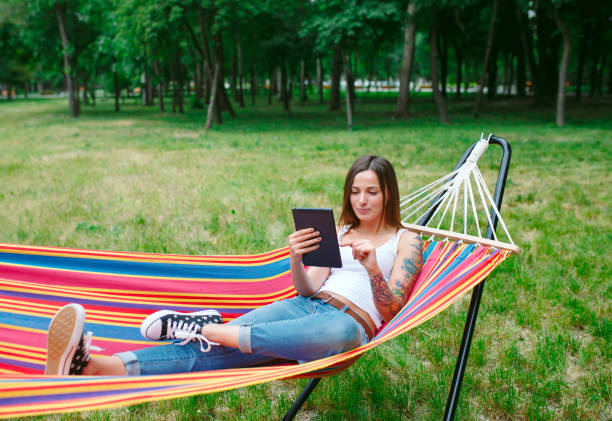 istock Young woman with tablet on the hammock. 1270043948