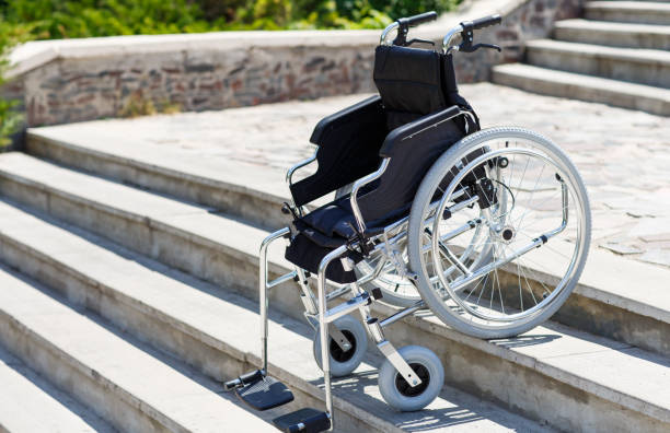 istock Wheelchair near the steps in a spring park. 1270044230