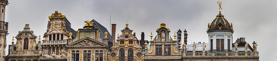 Baroque building facade boasts fine architecture and magnificent rooftop decorations in the Grand Place. Opulent exterior with guildhalls and renaissance outstanding ornaments - Brussels, Belgium