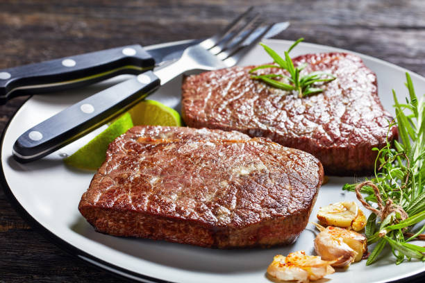 fried beef steaks with rosemary bouquet, garlic and salt