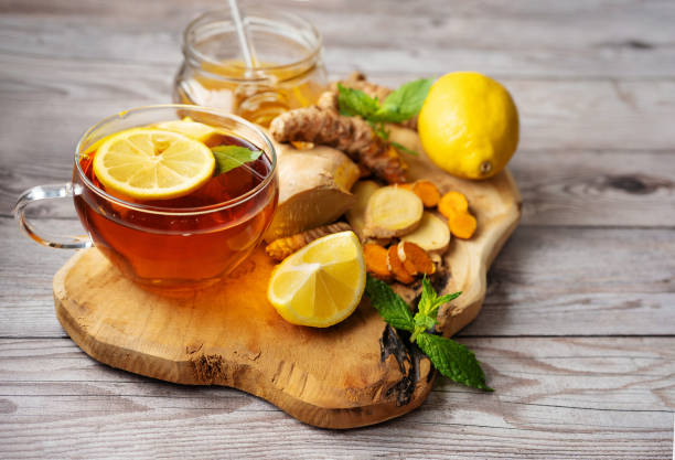 Ginger turmeric cup of tea on wooden board with ingredients