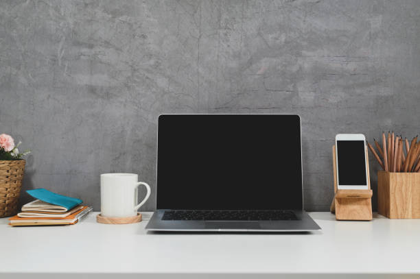 istock Loft workspace with laptop, smartphone, coffee and office supplies with concrete wall. 1270052194