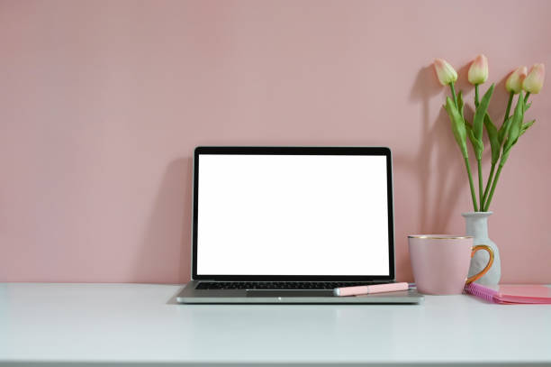 istock Pink workspace mockup laptop computer, notebook, pen and tulip flower with coffee. 1270052241