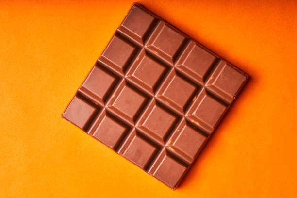 istock Bar of milk chocolate on a colored paper background 1270053535