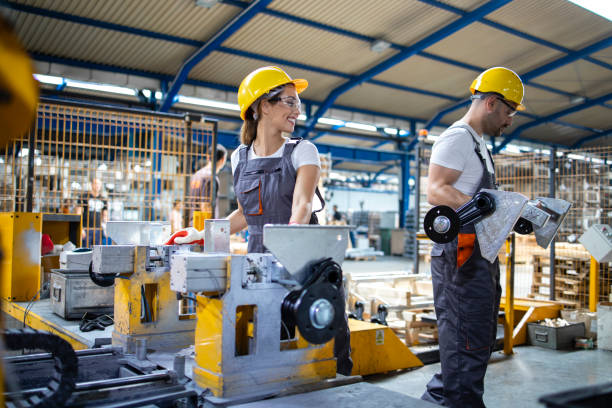 istock Factory production line workers standing by industrial machine and working together. 1270058492