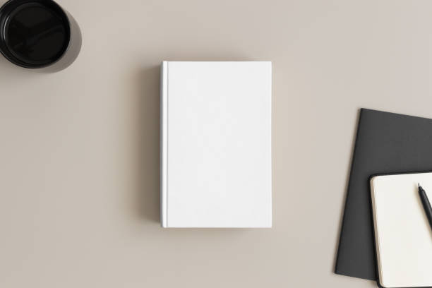 istock White book mockup with a cup of coffee and workspace accessories on a beige table. 1270059147