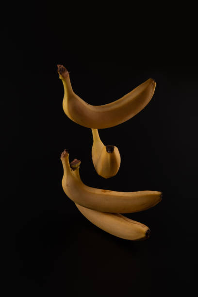 istock Elegant dancing isolated bananas behind black paper background 1270059669