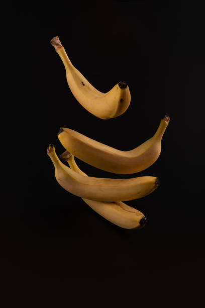 istock Elegant dancing isolated bananas behind black paper background 1270059680