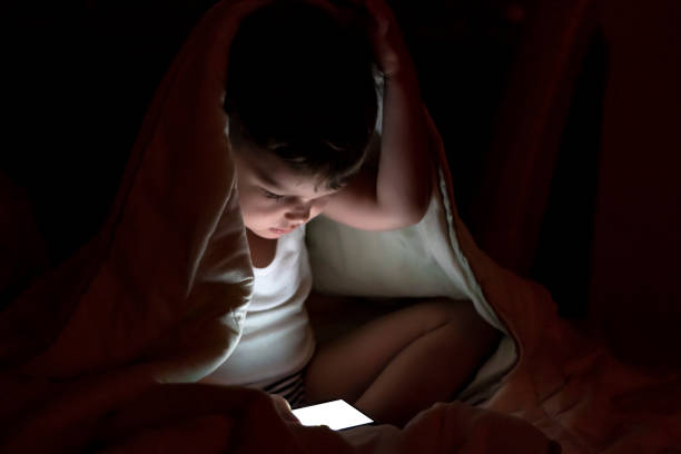 istock Boy watching a movie at night. 1270063206
