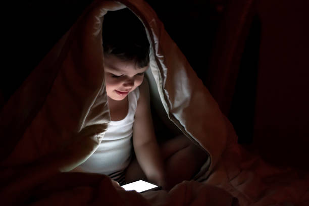 istock Boy watching a movie at night. 1270063422