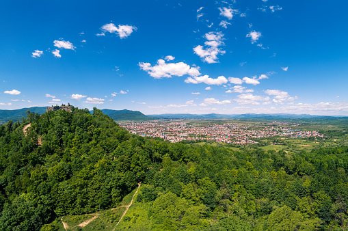 Panoramic view of Ruins of Khust Castle on the mount and mountain valley with Khust city. View from above. Zakarpattia Oblast, Ukraine, Europe. Aerial survey