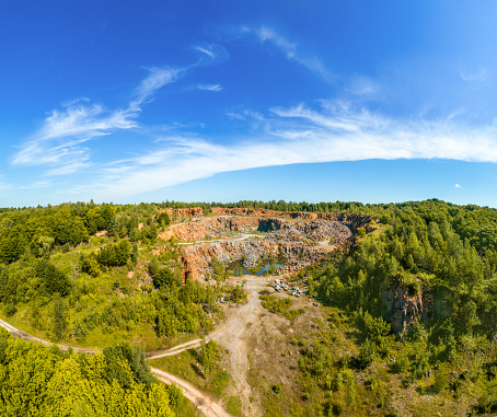 View from above of granite quarry in the forest. Mountain landscape on a summer sunny day