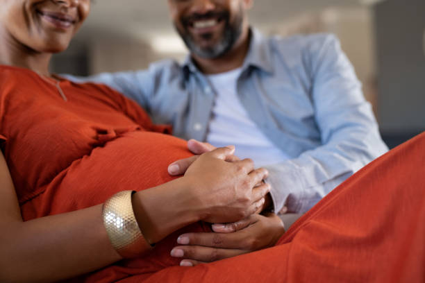 futur père sentant la bosse de bébé de femme enceinte - abdomen adult affectionate baby photos et images de collection