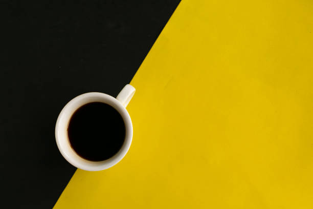 istock Coffee cup on geometric black and yellow background, top view, copy space for the text, minimal concept 1270067439