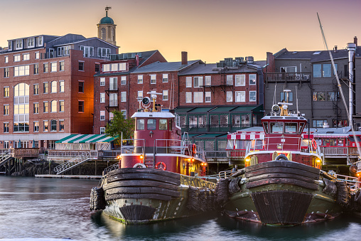 Portsmouth, New Hampshire, USA town cityscape with tugboats in the morning.