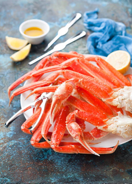Snow crab legs Snow crab legs plate with lemon and butter sauce, selective focus snow crab photos stock pictures, royalty-free photos & images