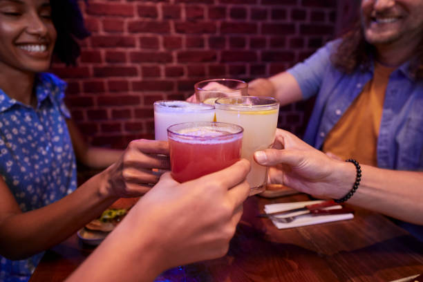 Close-up of toasting with glasses of lemonade and juice in retro restaurant