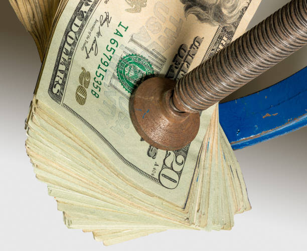 istock USA twenty dollar notes being squeezed between the solid jaws of a vise or vice 1270080335
