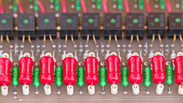 Obsolete red power carbon or green metallized resistors and black opto-isolators in rows. E-waste disposal. Eco