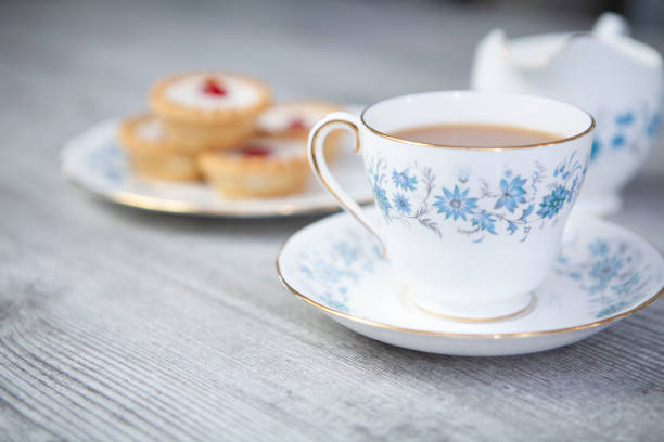 istock Cup of tea and cherry Bakewell tarts on a light wooden surface with copy space 1270082245