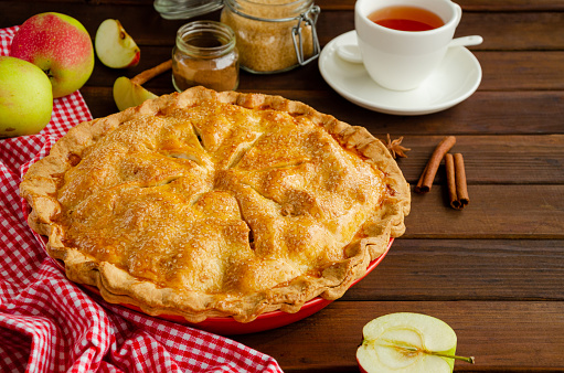 Classic American apple pie with cinnamon on a dark wooden background. Rustic style. Copy space