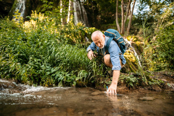 istock Hiker refreshing himself in mountain creek 1270084764