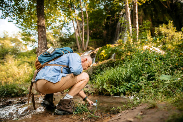 istock Hiker refreshing himself in mountain creek 1270084822
