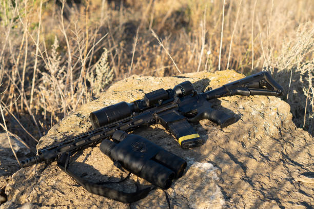 istock A rifle with a telescopic sight and binoculars on a stone background. Hunting and observation technologies 1270088058
