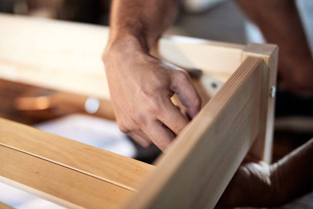 istock Carpenter hobbyist assembling wooden boards at home / garage. 1270088878