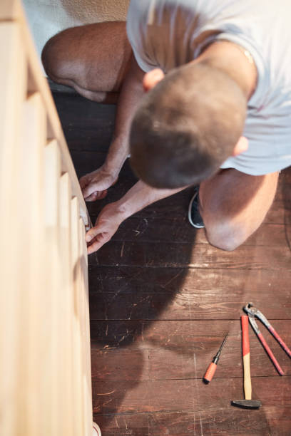 istock Carpenter hobbyist assembling wooden boards at home / garage. 1270088910