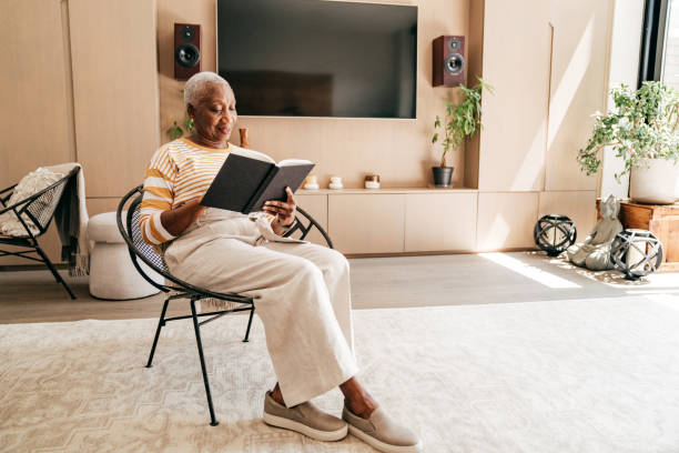 istock Senior woman reading analog book at home 1270092173