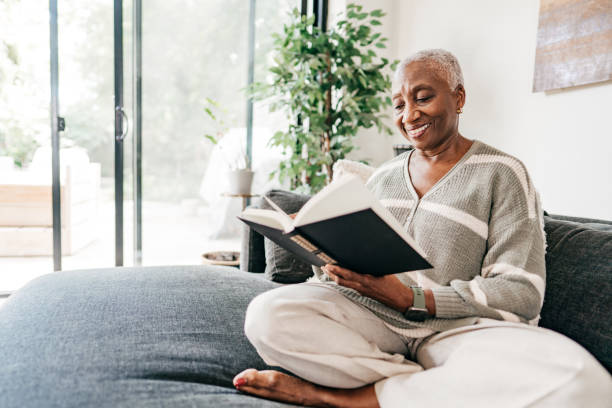 istock Senior woman reading analog book at home 1270092175