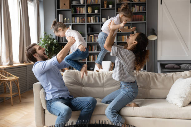 istock Young couple parents lifting on arms joyful laughing daughters. 1270093640