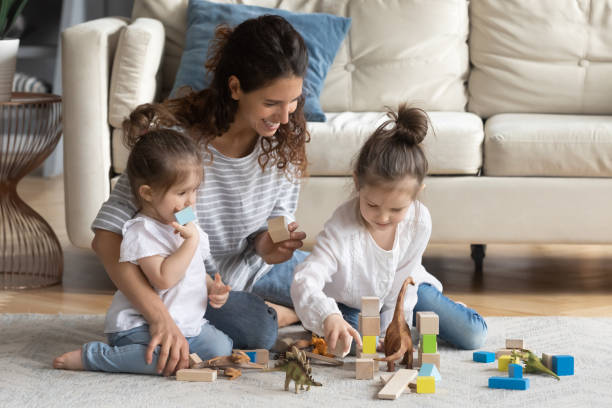 istock Smiling beautiful young mother enjoying playing with cute daughters indoors. 1270093648