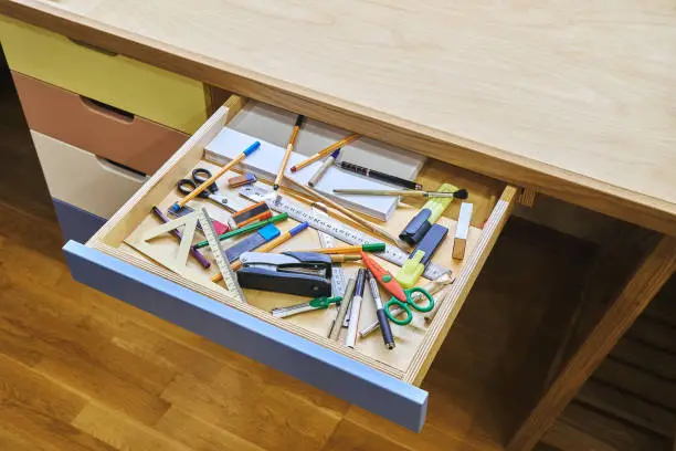 Photo of Open desk drawer with unsorted various school supplies
