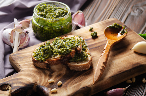 Small sandwiches with genovese pesto sauce made of basil, pine nuts, olive oil, parmesan cheese and garlic