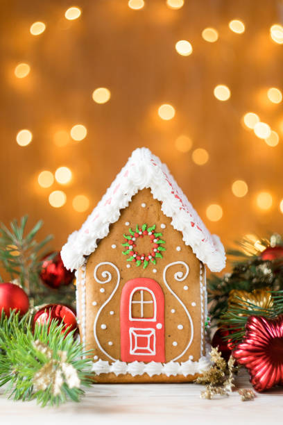 istock Beautiful gingerbread house with pine branches and christmas decotations, lights in background, vertical orientation, selective focus 1270095717