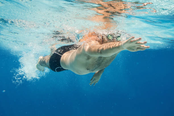 pro swimmer in the blue water swimming pool. underwater fitness, training and workout concept with copy space. - blue water swimming pool sports and fitness imagens e fotografias de stock