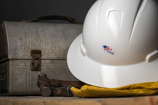 Photograph old lunch box and hard hat with I voted sticker.