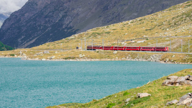 paso de montaña bernina. el famoso tren rojo está cruzando el lago blanco. increíble paisaje de la tierra suiza. lo mejor de swiss. destino famoso y atracción turística - white lake fotografías e imágenes de stock