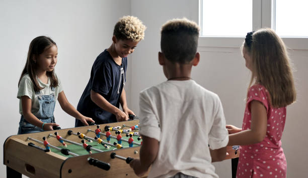 istock Group of multicultural children playing foosball 1270103970