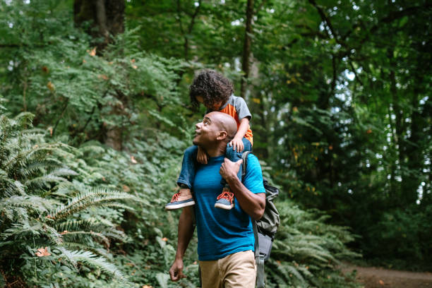 padre lleva a su hijo en caminata a través de sendero forestal en el noroeste del pacífico - northwest frontier fotografías e imágenes de stock
