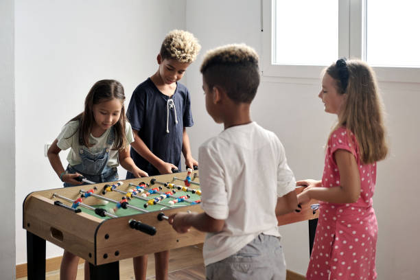 istock Group of multicultural children playing foosball 1270104093