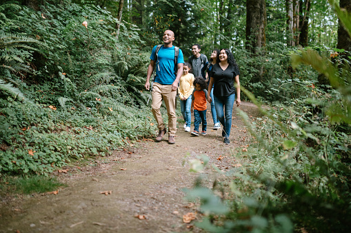 A young mixed race family spends time together outside in Washington state, enjoying the beauty of the woods in the PNW.