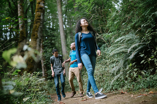 A young mixed race family spends time together outside in Washington state, enjoying the beauty of the woods in the PNW.