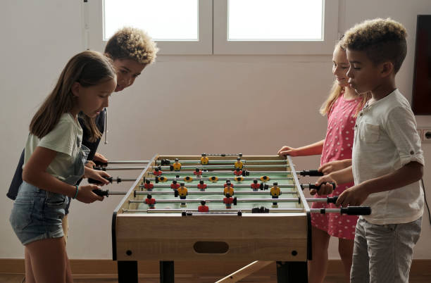istock Group of multicultural children playing foosball 1270104164