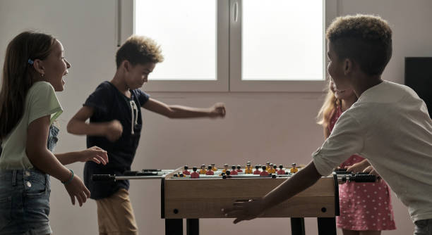 istock Group of multicultural children playing foosball 1270104217